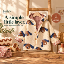 Front three-quarter view of a cream dog-print sherpa and rust gingham hooded jacket on a wooden hanger, with hood relaxed behind the neckline. PDF sewing pattern.