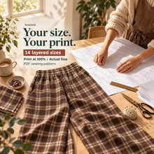 Print/setup artwork showing rich cocoa-brown and warm cream windowpane plaid wide-leg pants with elastic waist and front pockets. Hemlark digital sewing pattern.